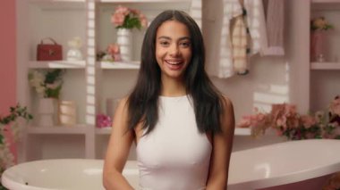 Latin, mutlu, etnik, mutlu, neşeli, zarif, dişlek, pembe banyoda gülümseyen, moda, sağlıklı güzellik, makyaj, işaret desteği, mükemmel cilt bakımı, diş bakımı.