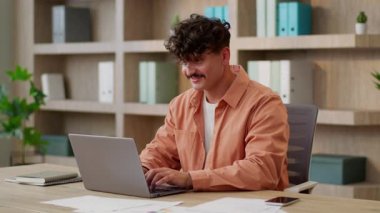 Kafkasyalı mutlu bir adam, erkek işadamı, işadamı, yöneticinin ofisteki bilgisayar kullanmasına şaşırdı. Kumarda başarıyı online olarak kutladı.