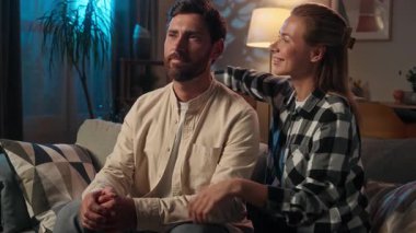 Beyaz kadın, erkek erkeğe sarılıyor. Kız, gece evde sarılıyor. Sevecen, sevgi dolu bir çift, aile babası, kanepeye sarılıyor.