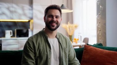 Mutlu, Avrupalı model erkek, ev sahibi, ev sahibi, iş adamı, gülümseyen kameraya bakan, tamam jestini onaylayan, evde iyi bir oturma odası tavsiye eden müşteri.