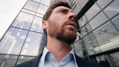 Hareket eden kamera zoom Kafkasyalı endişeli işadamı ofis binası yakınlarında kaybolmuş iş adamı erkek işveren işvereni cep telefonu GPS navigatör uygulaması kullanıyor.