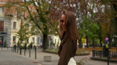 Şık, mutlu, mutlu, neşeli, neşeli, modaya uygun, beyaz, kadın, iş kadını, güneş gözlüğü takan bir bayan.