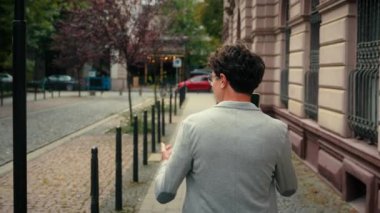 Tanınmayan bir iş adamının arkasından geriye dönüp bakmak bilinmeyen bir iş adamı erkek işadamı işveren şehre yürüyen bir girişimci dışarıda yürüyen cep telefonuyla konuşan akıllı telefon konuşmaları yapan bir girişimci.