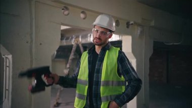 Kızgın Kafkasyalı ustabaşı erkek mühendis elinde matkap tutan mühendis fabrika inşaat işçisinde sondaj yapıyor tamirat tamircisi bağırıyor