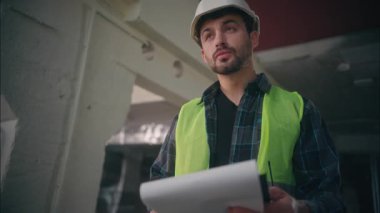 Ciddi Kafkas erkek mühendis mekanik müteahhiti tablet ustabaşı fabrika atölyesinde taslak yapısını planlayan mimar tasarım müfettişi endüstriyel üretim kontrolünü çiziyor.