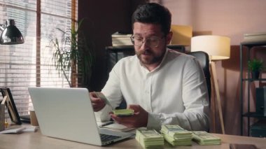 Kafkasyalı iş adamı şirket yöneticisi maaşları sayıyor... iyi dolar banknotlar... yönetici erkek... ofis işindeki nakit parayı tutuyor... finans şirketine para yatırıyor...