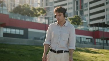 Beyaz adam dans ediyor, müzik kulaklıkları dinliyor, kulaklık takıyor, hafta sonu keyfine bakıyor, ses çıkarıyor, enerjik erkek şarkıları söylüyor, neşeli iş adamı, mp3 öğrencisiyle konuşuyor.