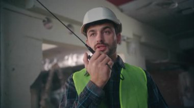 Ciddi Kafkasyalı işçi yönetici tamirci telsiz konuşan mimar fabrika kontrolörüyle mimari proje sipariş eden mimar inşaat mühendisi kontrol imalatçısı