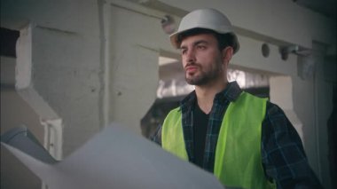 Kafkas müteahhit ustabaşı ustabaşı elinde planlı mimar erkek elektrikçi çalışanını denetliyor fabrika inşaat mühendisi müteahhidi müteahhitliği taslak denetliyor.