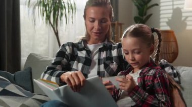 Beyaz aile, evde oturma odasında küçük kız çocuk kız çocuk, alet bağımlısı cep telefonu akıllı telefon video oyunu, anne-kadını görmezden gelip omuz silkmeyi teklif ediyor.