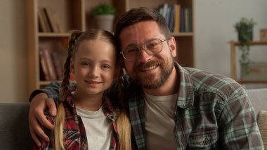 Kaygısız, beyaz bir baba, neşeli bir erkek, liseli bir kızı kucaklıyor, çocuk ailesini kameraya alıyor, küçük bir kız, gülümseyen bir çocuk, çocuk bakıcısı, babasıyla kucaklaşıyor.