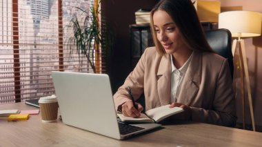 Mutlu Kafkasyalı iş kadını kız iş kadını ofis müdürü sekreteri jest, online laptop toplantısı konferansı içeride notlar yazmayı planlayan müşterilere danışmanlık yapıyor.