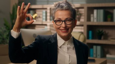 Ofiste gülümseyen mutlu beyaz kadın. 50 'li yaşlarda iş kadını. Emekli iş kadını. Yetişkin yönetici.
