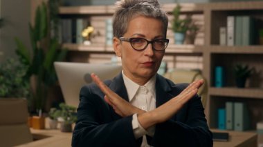 Ofis Negatif Kafkas kadın iş kadını olgun kıdemli işveren yaşlı orta yaşlı girişimci ön durak savunmasında ellerini çapraz yaptı.