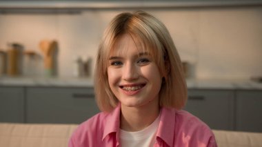 Mutlu bir portre diş teli diş sağlığı diş sağlığı diş sağlığı diş sağlığı ağız sağlığı gülümsemesi olumlu ruh hali gülüşü Kafkasyalı genç kız öğrenci bayan ev sahibi kameraya bakıyor.