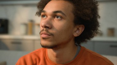 Kapalı portre sakin ciddi Afro-Amerikan erkek adam yan yana bakıyor kamera sağlıklı düşünceli yüz bakımı ev sahibi koca cilt tıbbı yüz ifadesi