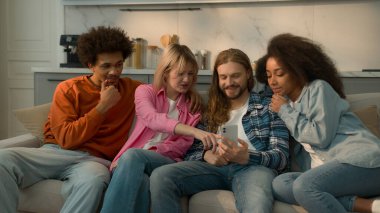 Çok ırklı insanların çeşitliliği erkekler erkek Afrikalı Amerikalı kadınlar Kafkasyalı kadınlar kanepe kanepede arkadaşlık cep telefonuyla konuşma sipariş sosyal medyası hakkında konuşma