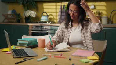 Birden fazla görev yapan kız lise öğrencisi Latin kadın işkadını uzakta okuduğu için strese girdi. Mutfakta ev ödevi yazdı. Serbest çalışan evde zor bir not defteri yazma sorunu yaşadı.