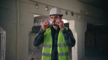 Ciddi Kafkasyalı tamirci tamirci. İnşaat fabrikasında güvenlik gözlüğü takıyor. Mühendis.