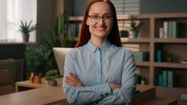 Portre gülümseyen kız iş kadını bayan işveren yönetici kameraya çapraz el ele bakan kadın kendine güvenen iş kadını mutlu lider ofis sahibi millennial