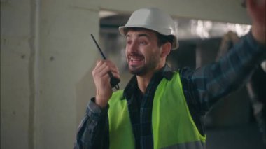 Beyaz adam ustabaşı inşaat süreci yöneticisi erkek inşaatçı radyo aygıtı telsizinden konuşan profesyonel müteahhit inşaat mühendisi mimar tamir binası