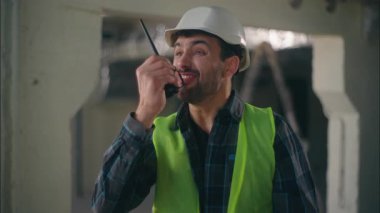 Kızgın beyaz adam telsiz telsizinden çığlık çığlığa bağırıyor. Kızgın erkek müteahhit. El bileğini geç gösteren çılgın adam.