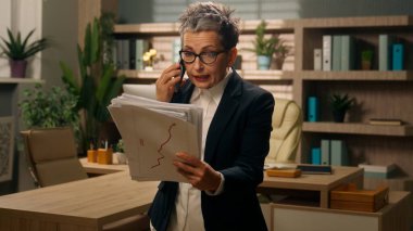 Öfkeli, öfkeli, yaşlı, olgun, yaşlı iş kadını, yaşlı, yaşlı iş kadını, kadın, patron, iş kadını elinde belgeler tutan girişimci hatayı bildiriyor.