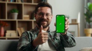 Beyaz erkek, gülümseyen yeşil ekran akıllı telefon uygulaması gösteriyor. Başparmağınızı kaldırın. İyi bir online alışveriş sitesi Chroma Keyt Mobile bahse kumarhane kumarhanesi gibi.