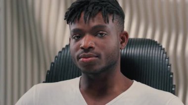 Portre yüzü fütüristik kendine güvenen ciddi oyun programcısı fütürizm modern beyaz oda stüdyosunda erkek Afrikalı Amerikalı adam göz kırpan göz kırpma teknolojisine bakıyor.