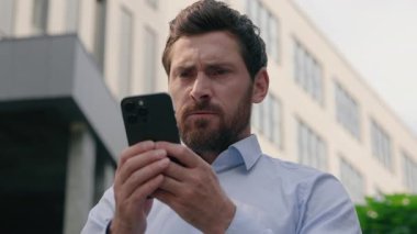 Sinirli, sinirli, sinirli, sinirli, beyaz, orta yaşlı iş adamı, iş adamı, iş adamı, şehirdeki iş adamı, cep telefonu uygulaması, akıllı telefon konuşmaları, akıllı telefon mesajı, iş yeri sorunu.