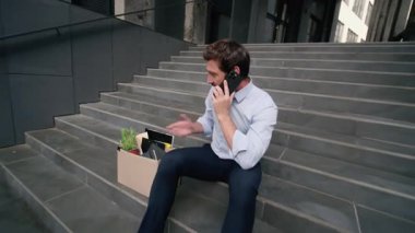 Öfkeli öfkeli öfke, işsiz, Kafkasyalı, orta yaşlı, iş adamı, şehirde cep telefonuyla bağıran, işten çıkarma kutusuyla konuşan yetişkin bir adamın işten çıkarılması sorununu gündeme getirdi.