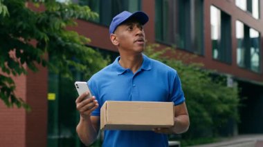 Düşünceli Afro-Amerikan kurye, erkek postacı, küçük iş yeri araştırması, cep telefonu kontrol adresi akıllı telefon teslimatı, kutu taşıma sorunu.
