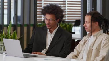 İki Afro-Amerikalı adam bilgisayardaki finansal büyümeye bakıyor. İyi sonuç pazarlaması başarısı çeşitliliği erkek iş arkadaşları dizüstü bilgisayarla kazanıyor. Beş jest işi.