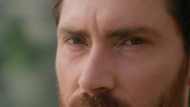 Aşırı yakın gözler, kırışık cilt, mutlu gülümseyen beyaz, düşünceli orta yaşlı iş adamı, şehirde yetişkin bir iş adamı, kameranın sağlık görüntüsü katarakt tıbbına bakıyor.