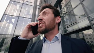 Sinirli, sinirli, sinirli, duygusal stresli, otoriteden hoşnutsuz, beyaz, orta yaşlı, yetişkin iş adamı, erkek, işveren, şehirde cep telefonu konuşmasını savunan, iş adamı.