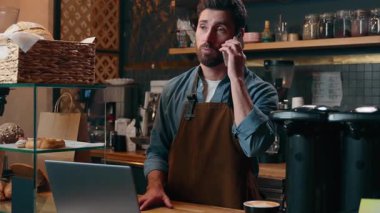 Neşeli Kafkasyalı erkek menajer erkek barista sahibi işçi cep telefonu müşterisi arıyor kafeterya personeli girişimcisi laptopçu barmeni servis servisi internet uygulaması kafeteryası