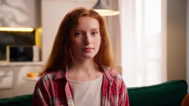 Kapalı portre beyaz kadın gülümsemesi sakin sakin kameraya bakıyor mutlu duygu ev oturma odasında başarılı yaşam tarzının tadını çıkarıyor ev kredisi kredisinin keyfini çıkarıyor.