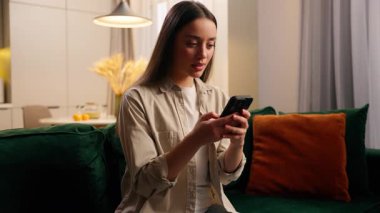 Hayal kırıklığına uğramış duygusal umutsuzluk. Beyaz kadın evinde cep telefonu arızasına bakıyor. Akıllı telefon dolandırıcılığı ve bahis kaybı hatası yüzünden hayal kırıklığına uğramış kadın.