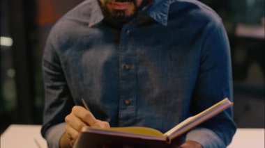 Düşünceli Hintli adam, gece ofiste çalışan iş adamının Arap iş adamı olduğunu düşünüyor. İşveren yöneticisi analist notlar yazıyor. Görev fikirleri düşünüyor. Not defterine yazmayı düşünüyor.