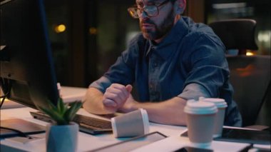 Kafkasyalı adam karanlık gece ofisinde uyuyan yorgun işadamı uykusunu kaybetti uykusuzluk sorunu fazla mesai erkek işkolik aşırı çalışma yorgun uyanık bilgisayar teslim tarihi stresli