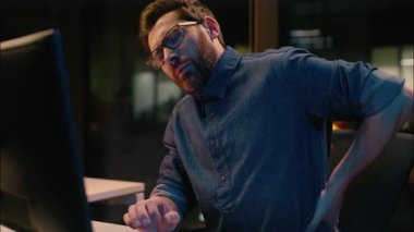 Kafkasyalı iş adamı profesyonel işveren. Karanlık gece ofisinde çok çalışan iş adamı. Sırt ağrısı çeken, sırtı ağrıyan bir bilgisayar.