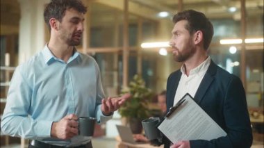 İki profesyonel iş ortağı iş ortağı iş yerinde birlikte kahve içerler. İş yerinde mola veren beyaz erkek çalışanlar, iş yerinde diyaloğu tartışırlar.