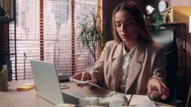 Kafkasyalı iş kadını kadın iş kadını, ofis çalışanı muhasebeci çok sayıda fatura okudu. Kağıt para kaybı, kriz, iflas, ev içi vergi, ev içi bilgisayar.