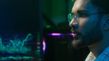 Arap Hindistanlı adamı kapat ve planlama analisti programcı kripto para birimi erkek işadamı iş adamı neon ofis profesyonel bilişim uzmanı strateji klavyesi üzerinde düşün.