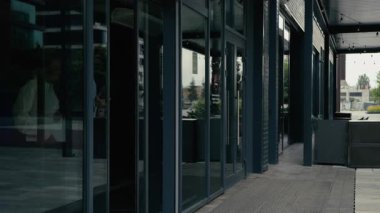 İki çok ırklı iş adamı birlikte şehir binasının önünde yürüyorlar. Afrika kökenli Amerikalı kadın iş kadını, beyaz erkek işadamıyla konuşuyor.