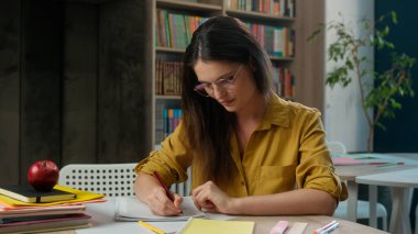 Kafkasyalı kadın ödev ödevi sınavı hazırlıyor kız liseli kız öğrenci, ilkokul öğretmeni, telif kitabı yazıyor. Masa başında üniversite eğitimi alıyor.