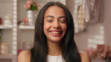 Mutlu bir portre mutlu bir kadın pozitif gülüyor İspanyol tarzı genç bir kadın pembe şekerli banyo şampuanları içinde güzellik spa cilt komik kız kameraya bakıp gülüyor dişlek dişlek tıbbi bakım