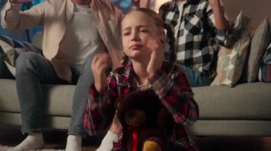 Korkmuş, stresli kız çocuğu, oyuncak ayıyla acı çekiyor. Kulakları kulaklarında bağırıyor, bağırıyor, kavga ediyor, kavga ediyor, anne baba tartışıyor.