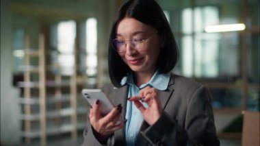 Asyalı iş kadını sanayi işçisi Çinli Koreli Japon kız iş kadını şirket mimarı cep telefonu şoku kullanarak Vay canına cep telefonuna göz gezdirme iyi haber