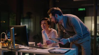 Çok ırklı takım arkadaşları Kafkas Hintli erkek kadın iş arkadaşları gece geç saatlerde çeşitli iş adamları ve iş kadınları birlikte bilgisayar projesini tartışıyorlar.